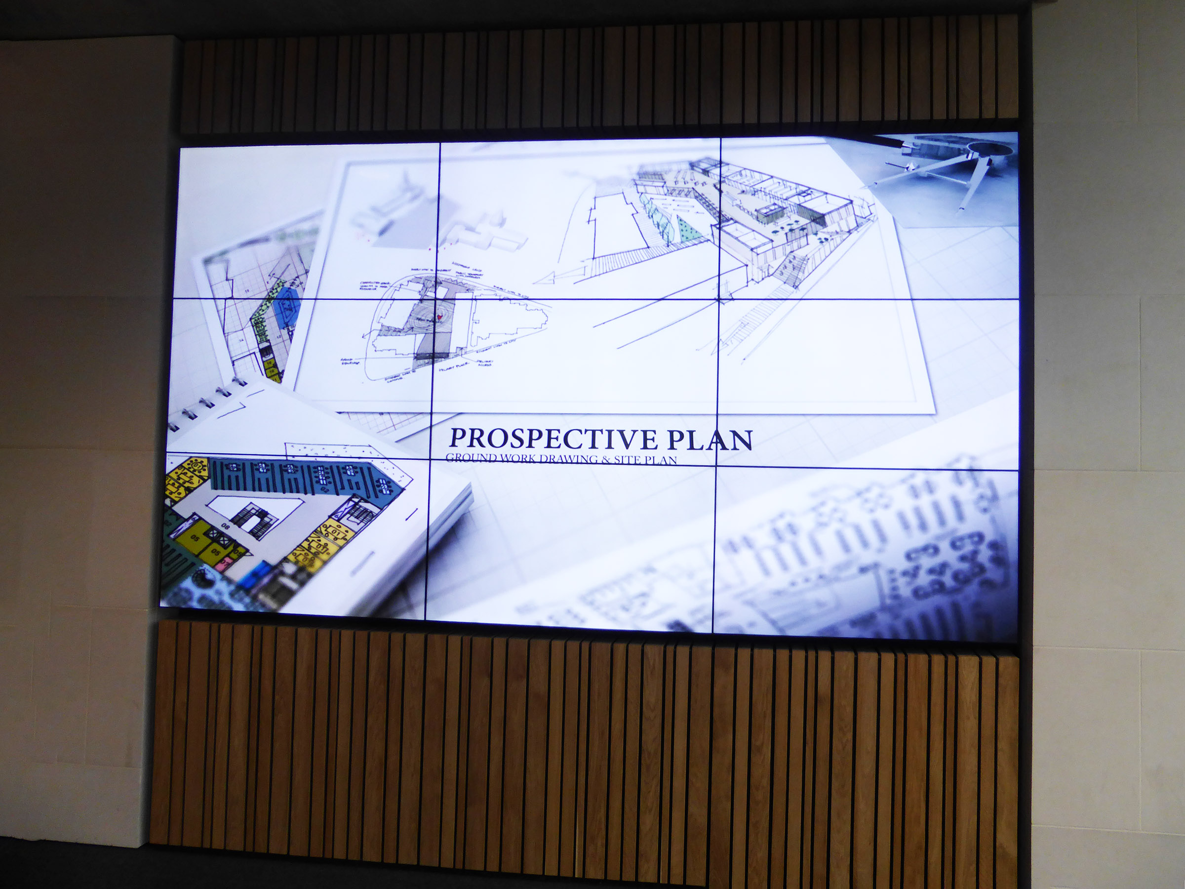 video wall in a library atrium showing architectural plans