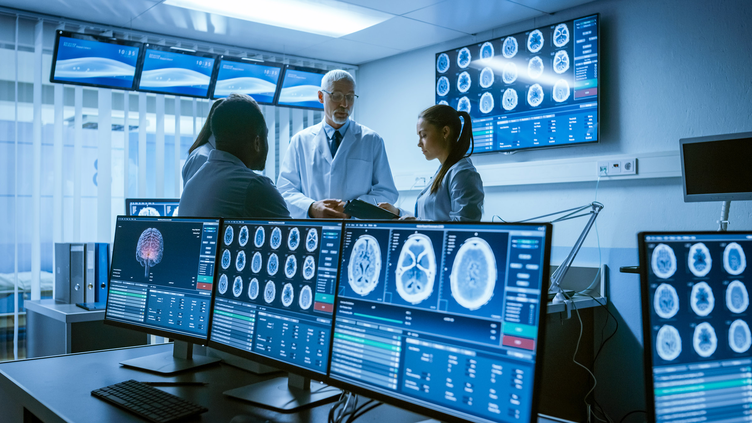 Group of doctors surrounded by screens in medical MDT Room