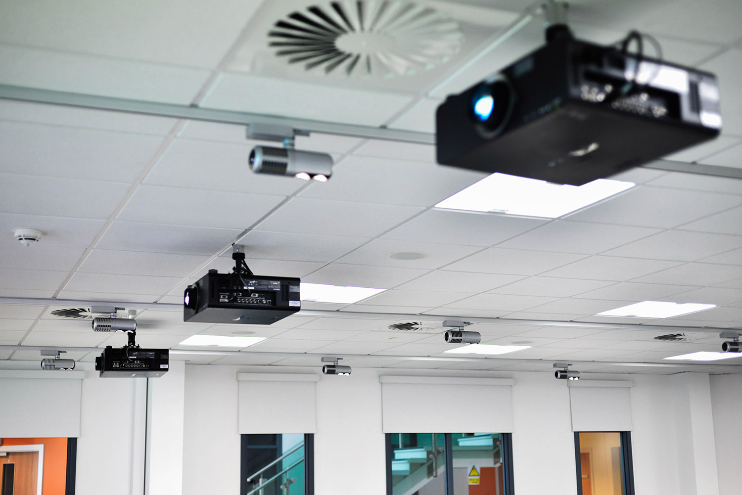 projectors flown from the ceiling of a university lecture theatre